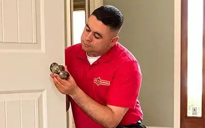 handyman installing door knob on four panel door