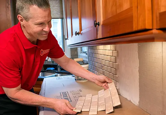 Mr. Handyman technician installing kitchen backsplash.