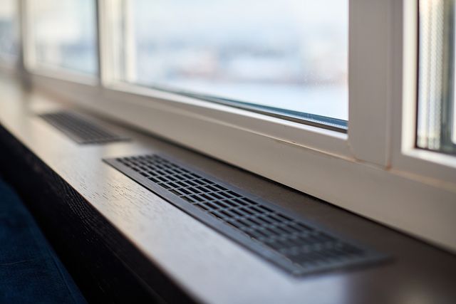 Air vent on wooden window sill.