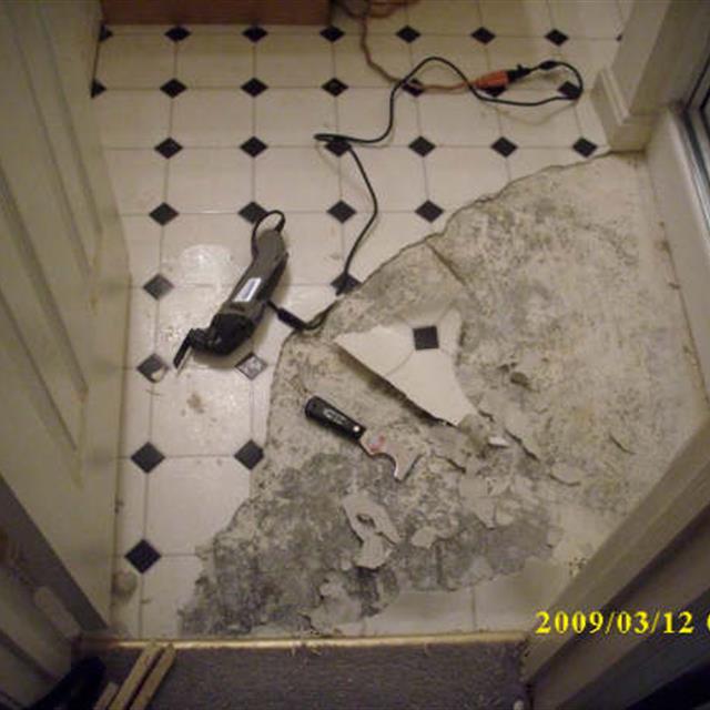 Picture of home bathroom tile floor being broken