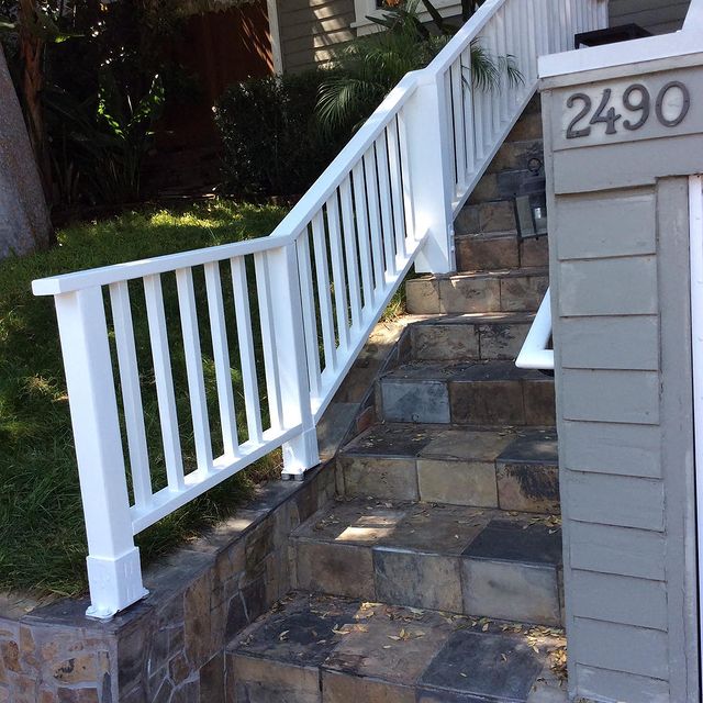 White outdoor fence with rock stairwell.