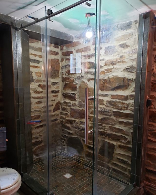 Frameless glass shower with stone tile