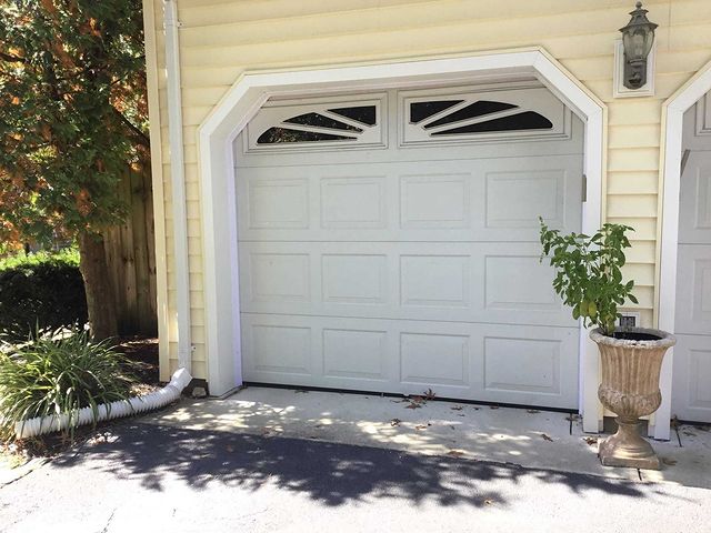 Garage door weatherstripping around white garage door on yellow house