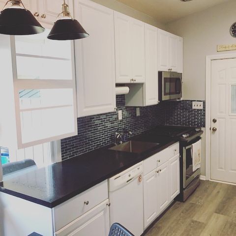 Kitchen with white cabinets and black countertops