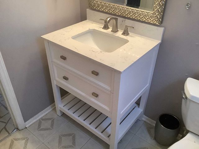 White vanity with marble countertop installed in bathroom