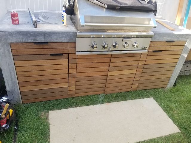 Outdoor grill with wooden custom cabinetry