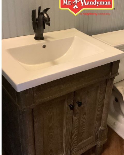 Stand alone wooden vanity sink with hardware.