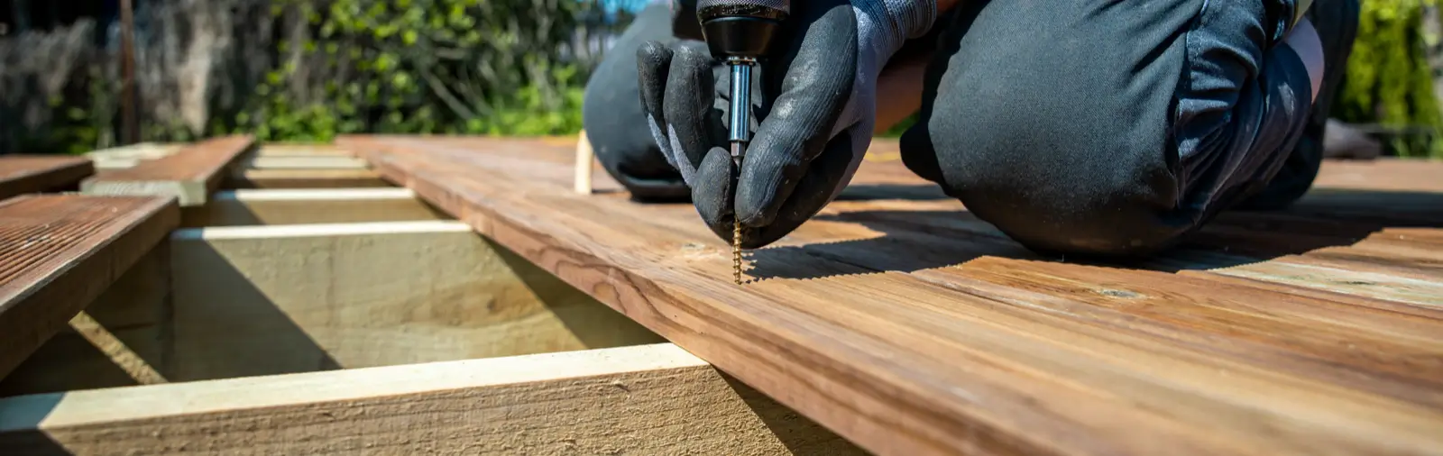 A Deck board being screwed down