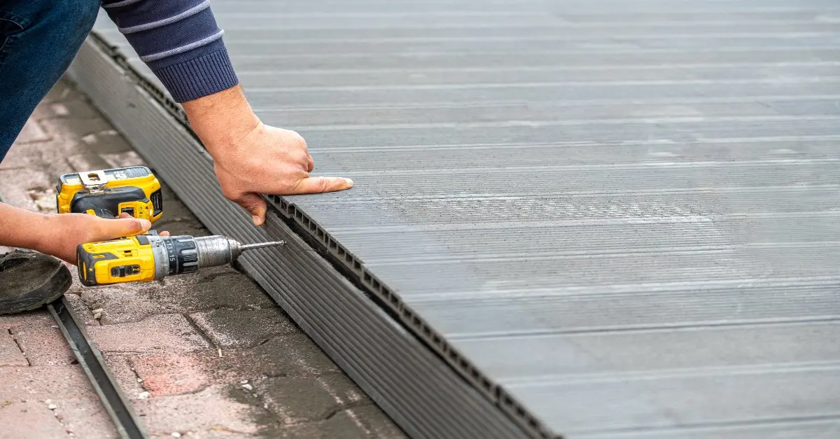 A handyman using a drill to complete deck repairs in West Palm Beach.