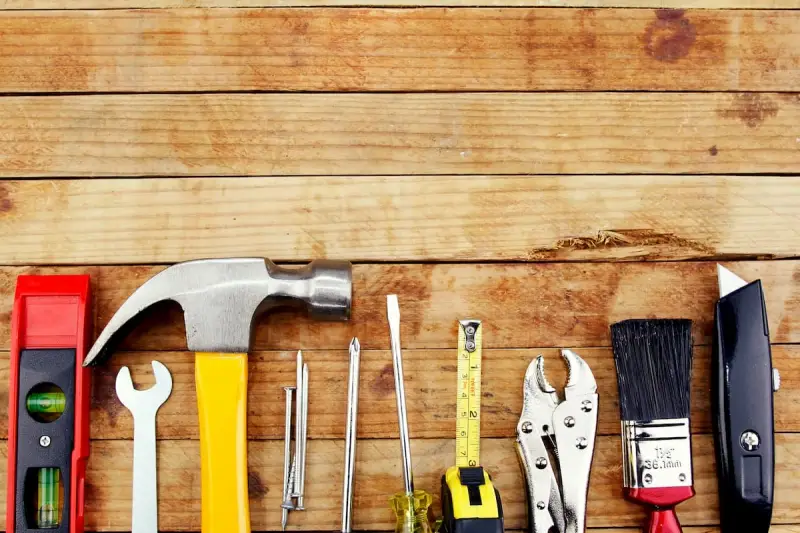 A variety of tools kept on a wooden table.