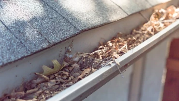 A white picket fence with broken pickets creating a hole that must be fixed with fence repair services.