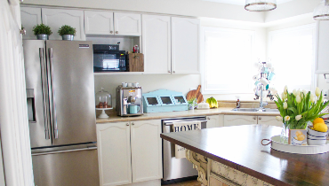 kitchen with large center island, stainless steel appliances and white cabinets