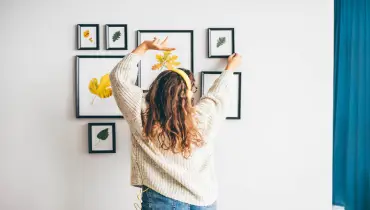 Woman hanging frames for a wall gallery