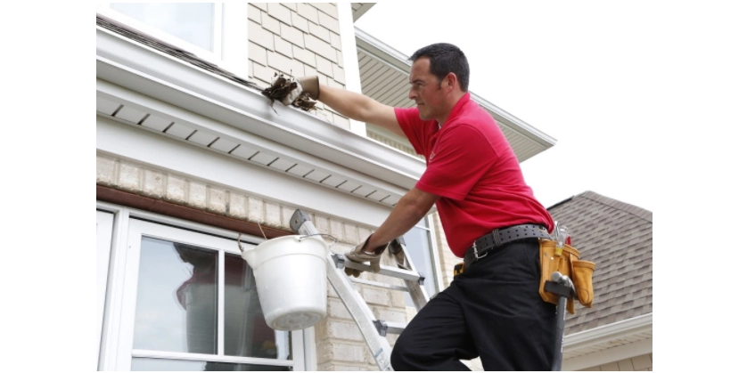 Mr. Handyman service professional performing gutter cleaning services.