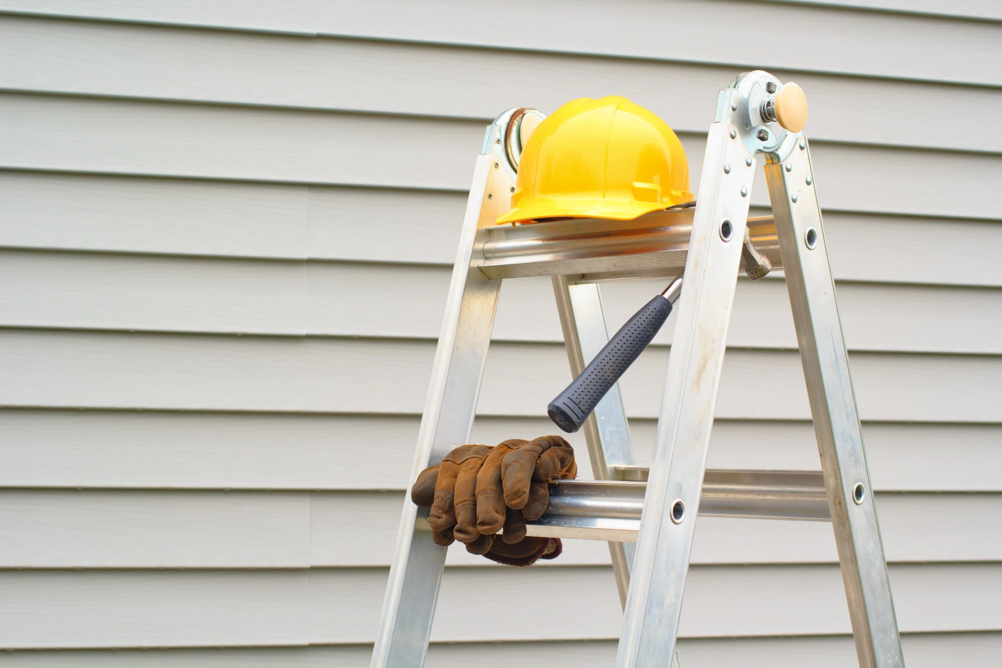 A ladder with a hard hat and gloves.