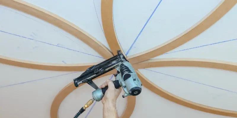 Curved wooden beams being installed as part of residential ceiling’s finish carpentry in Flower Mound, TX.