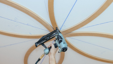 Curved wooden beams being installed as part of residential ceiling’s finish carpentry in Flower Mound, TX.