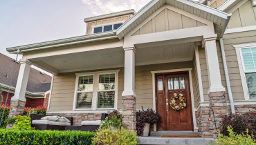 The covered front porch of a house that has been well maintained with porch repair services.