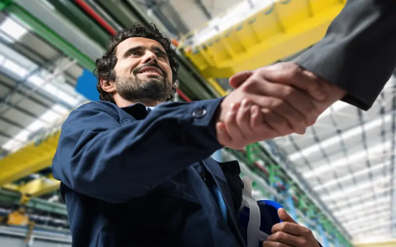 Photo of a bearded man shaking hands with someone off camera