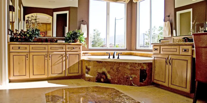 A completed bathroom remodel with a corner tub, new cabinets, and a new vanity.