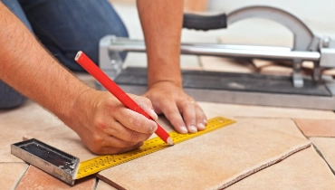 Floor tile repairs being rendered by a handyman.