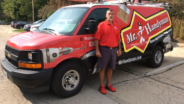 Mr. Handyman employee standing in front of wrapped van