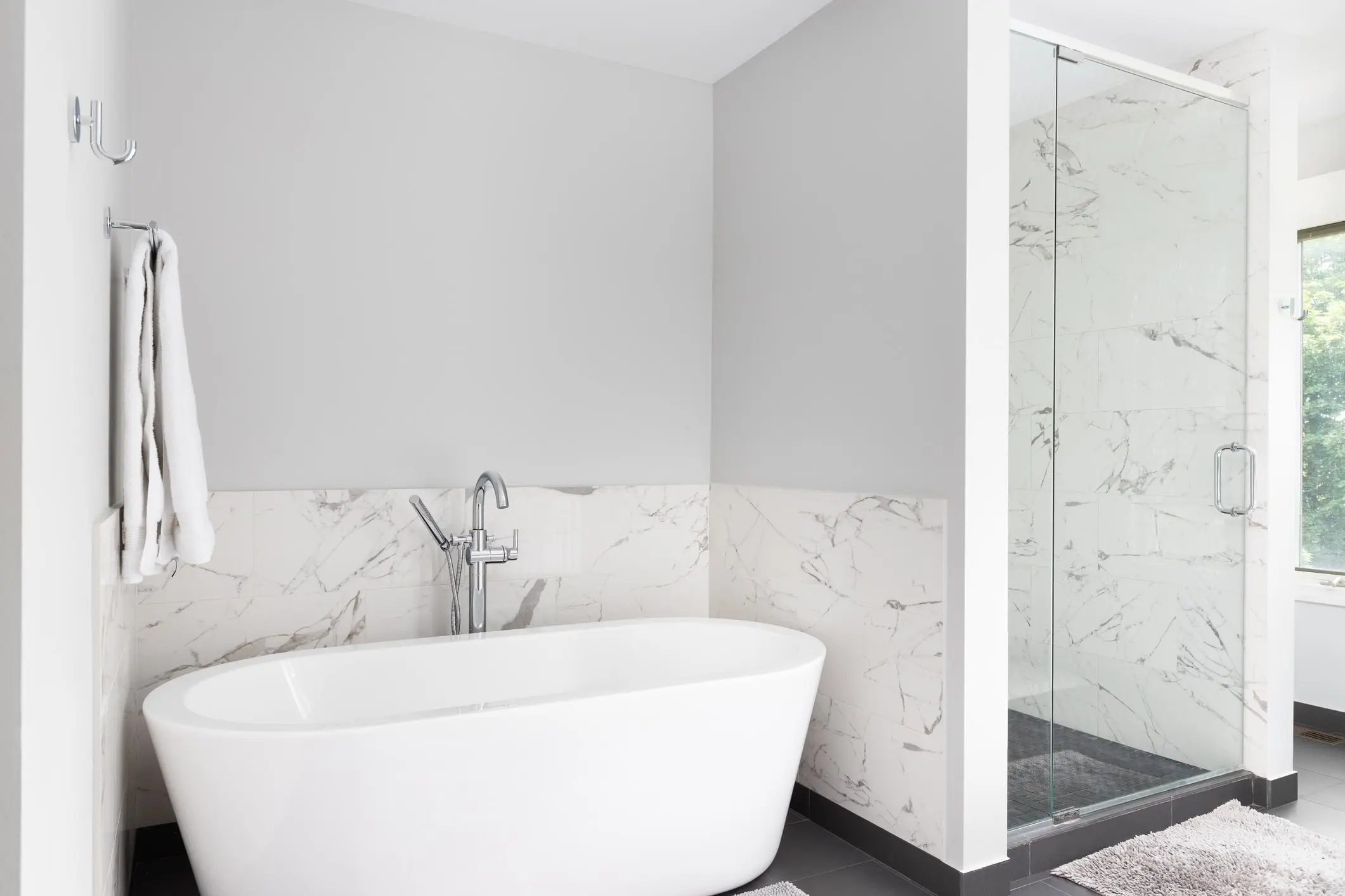 A bathtub next to a walk-in shower in a white bathroom.