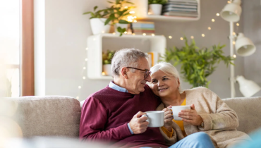 Elderly couple sitting in living room.