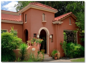 A charming house featuring a red tile roof and desert hues.