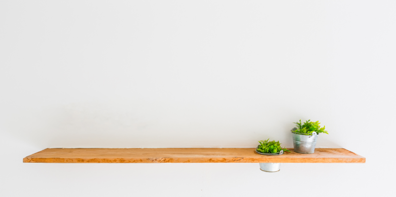 Floating wall shelf with potted plants on it.