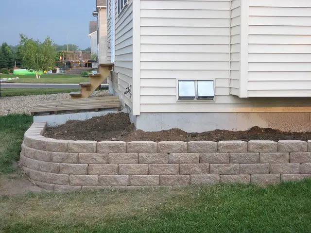 Stone retaining wall surrounding house.