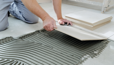 Laying floor tiles.