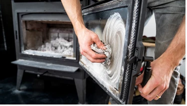 A person cleaning a stove.