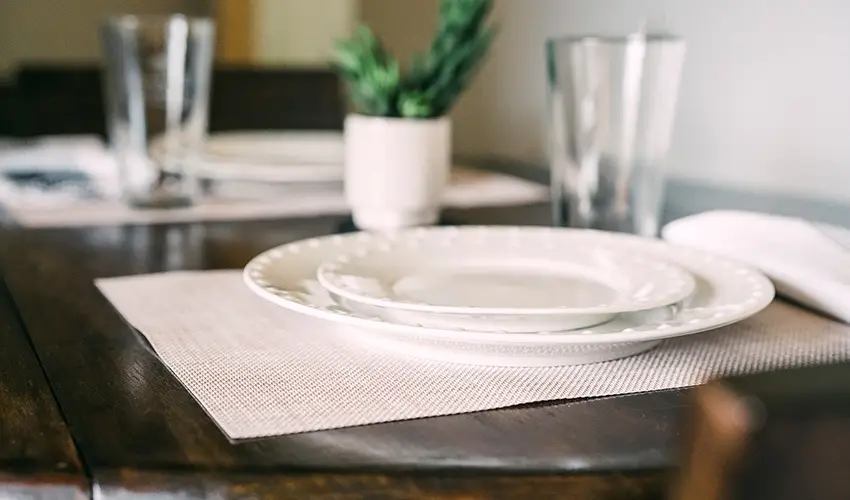 Wooden dining table with glass and plate.