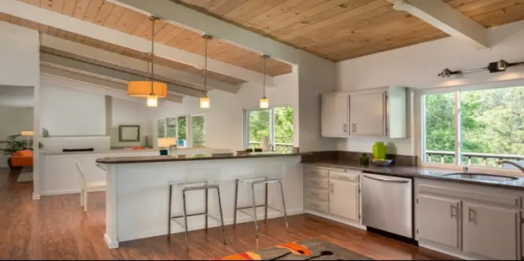 Kitchen with wood floor and bar stools.