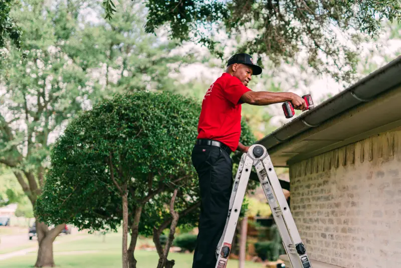 Man cleaning rain gutters.