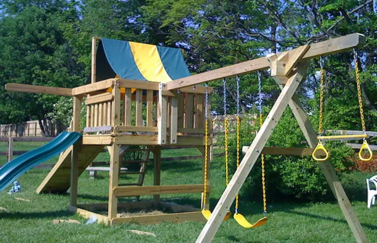 A wooden play set in a yard.