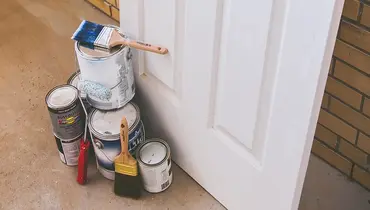 Paint cans next to a door.