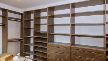 Large walk-in closet with many shelves and drawers.