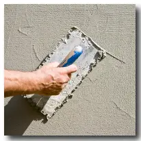 Mr handyman using a trowel to plaster a wall.