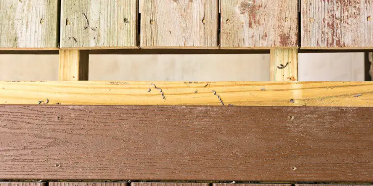 A deck with a gap between its old, weathered boards and the new boards being added during deck repairs.