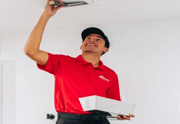 handyman performing drywall repair on the ceiling,