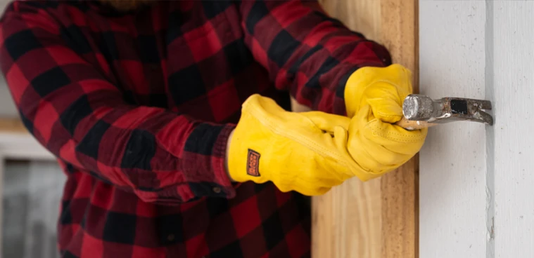 Man replacing siding on house.