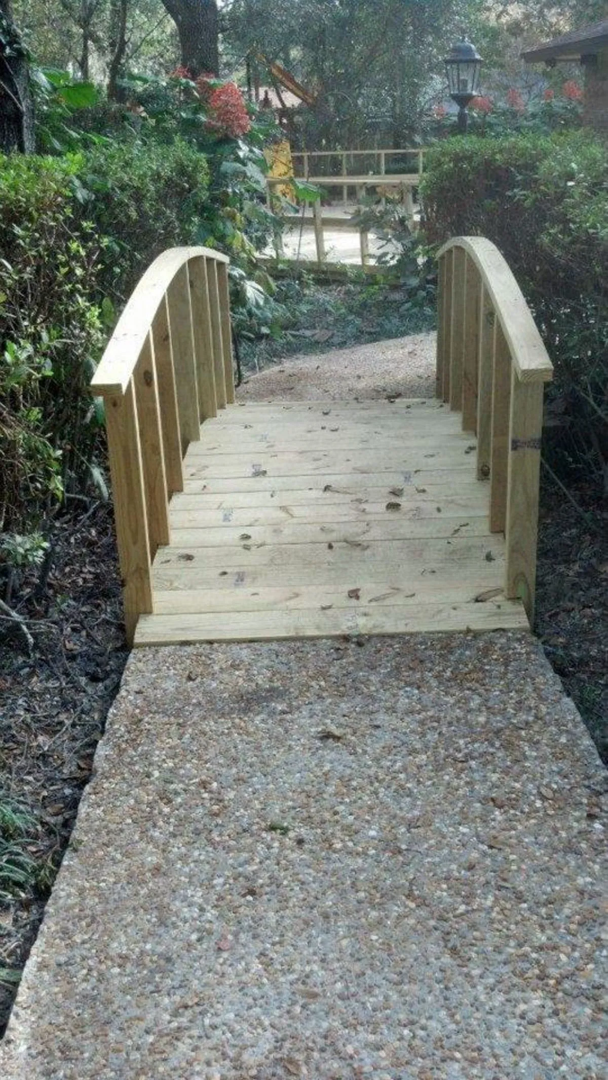 Freshly built wooden bridge over creek in backyard by a Jacksonville carpenter from Mr. Handyman.