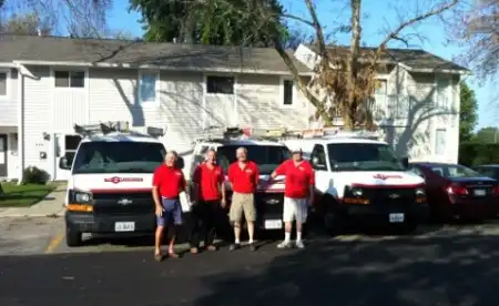 Mr. Handyman technicians in front of vans and nearby homes.