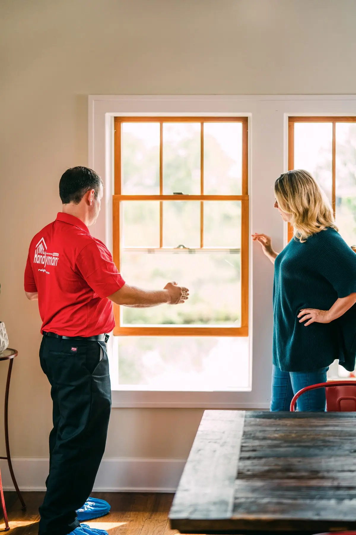 Handyman showing a window to a Mr. Handyman customer.