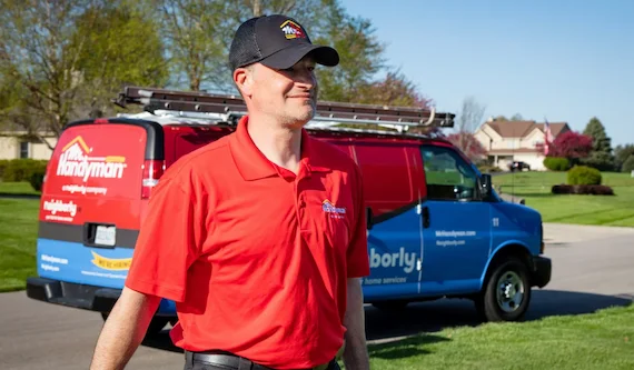 Mr. Handyman service professional in front of a branded van.