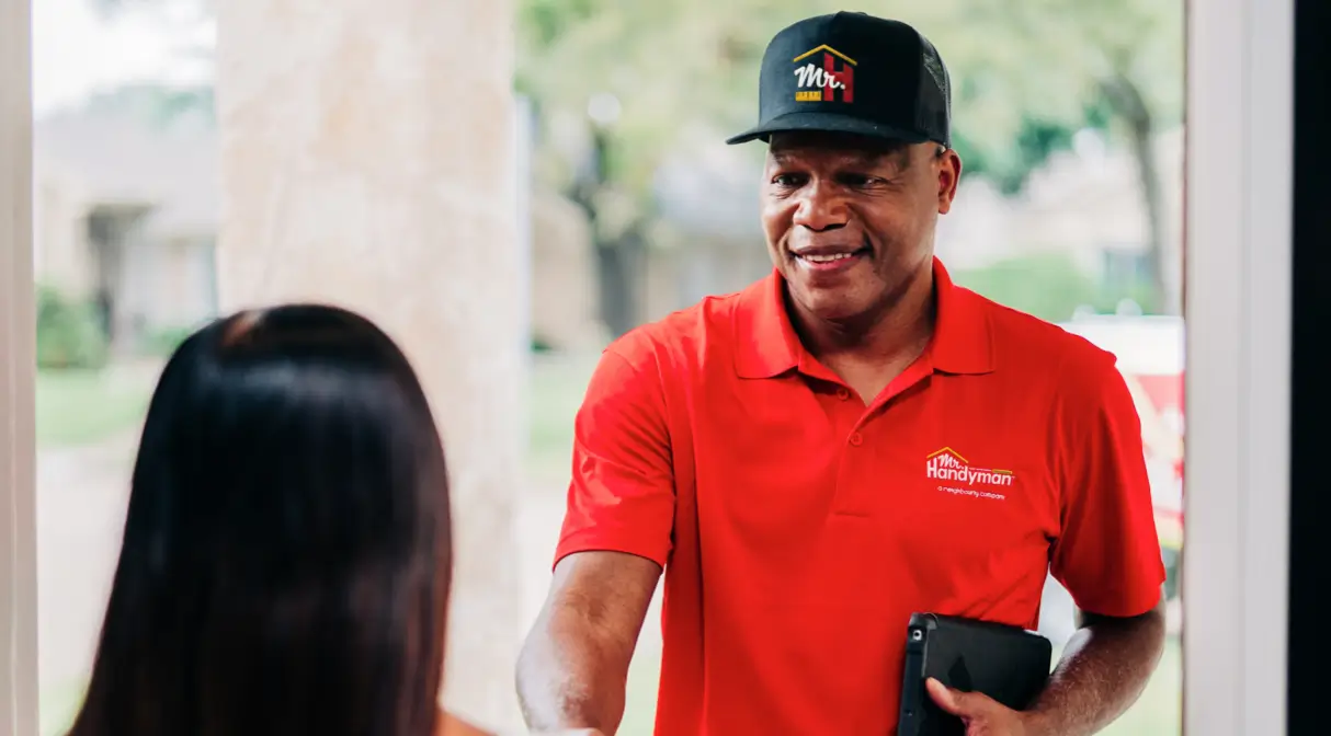A Mr. Handyman service professional greeting a customer.