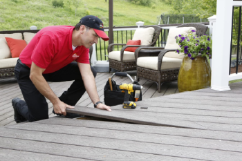 Handyman laying down composite boards on deck.