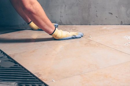 a Mr. Handyman of Princeton & Robbinsville employee repairing tiles